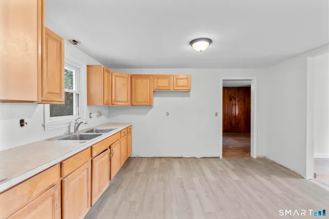 a view of a kitchen from a sink and dishwasher with wooden floor