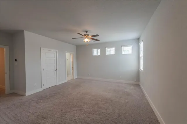 a view of an empty room with a chandelier fan