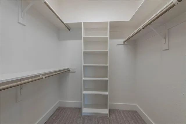 a view of walk in closet with empty racks