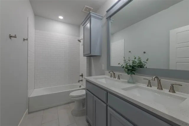 a bathroom with a granite countertop sink a toilet and shower