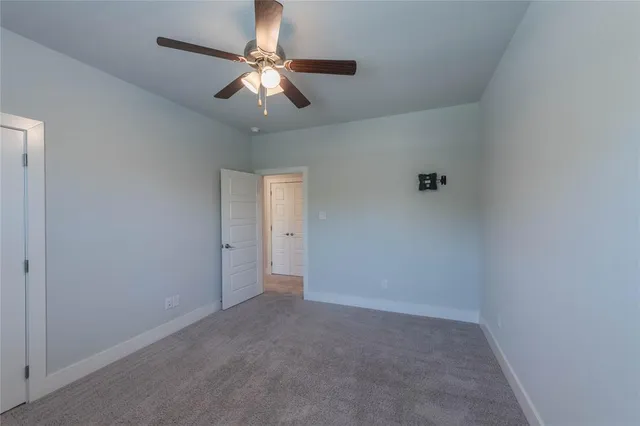 an empty room with a chandelier fan and a ceiling fan