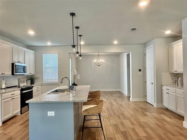 a kitchen with kitchen island a sink stainless steel appliances and cabinets