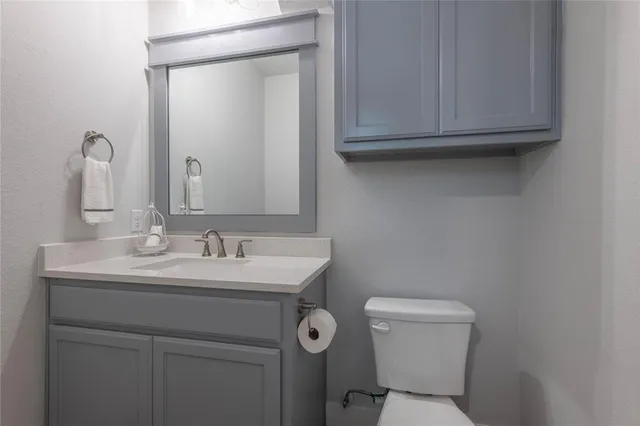 a bathroom with a toilet a sink and mirror