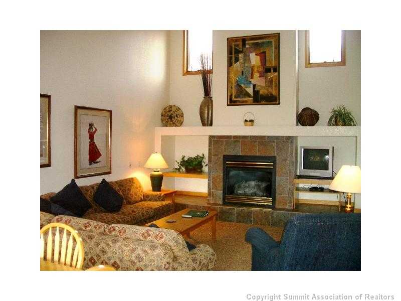 56 View Lane, Unit 7F Breckenridge, CO 80424 - Photo 11 of 16 a living room with furniture a fireplace and wall paintings