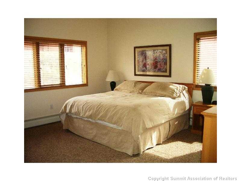 56 View Lane, Unit 7F Breckenridge, CO 80424 - Photo 12 of 16 a bedroom with a bed and wooden floor