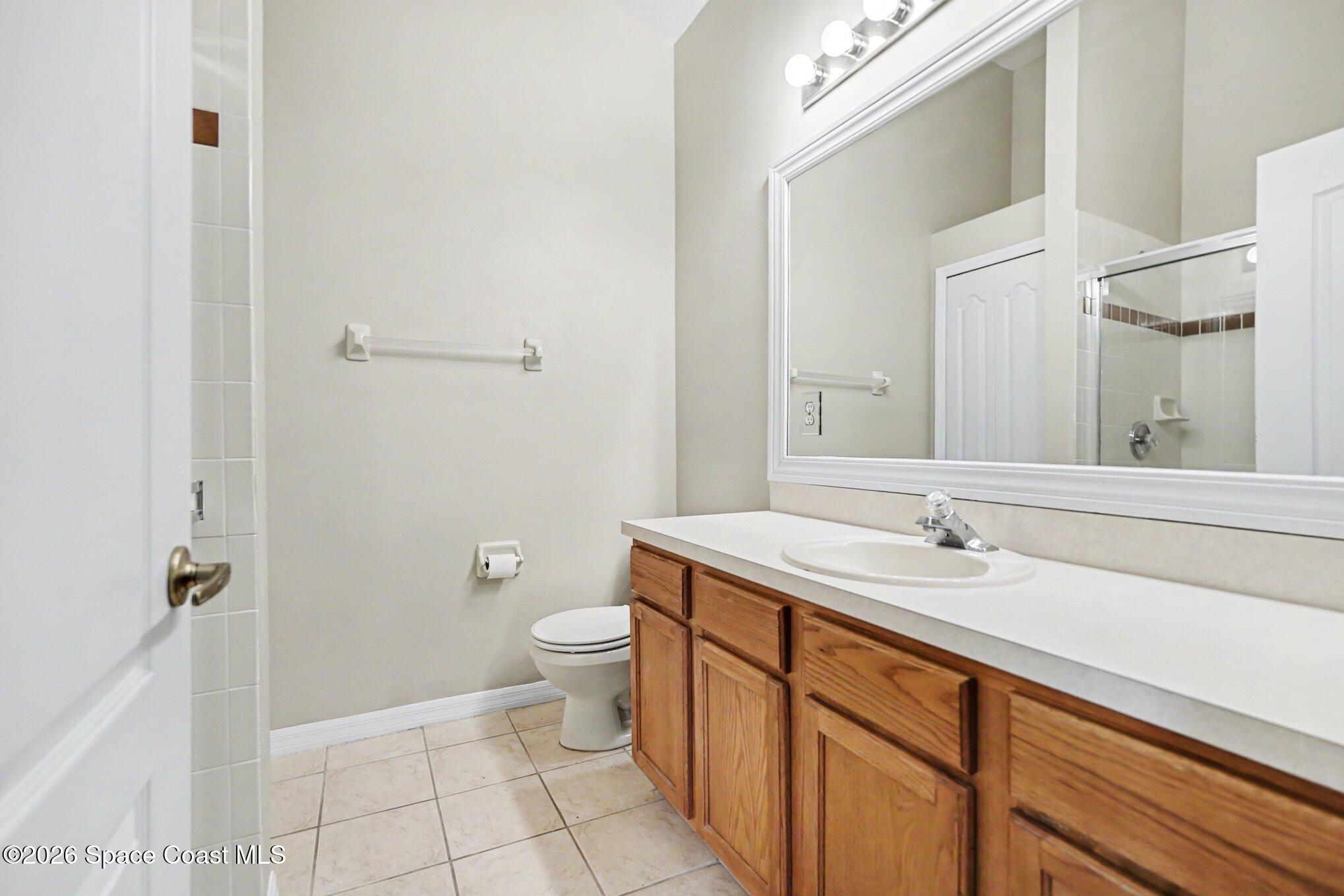284 Intrepid Way Indialantic, FL 32903 - Photo 23 of 36 a bathroom with a granite countertop sink a toilet and a mirror
