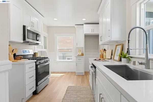 a kitchen with stainless steel appliances a stove a sink and a refrigerator