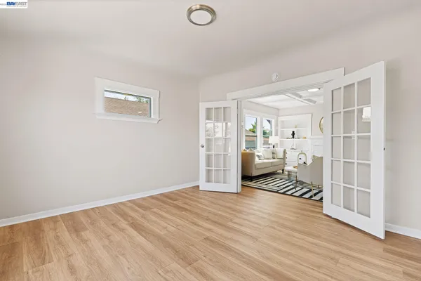 a view of empty room with wooden floor and fan