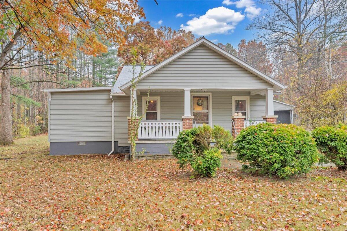 a front view of house with yard and trees around