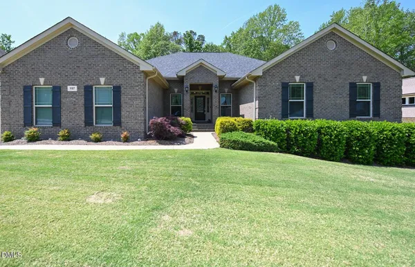 a front view of a house with yard and green space