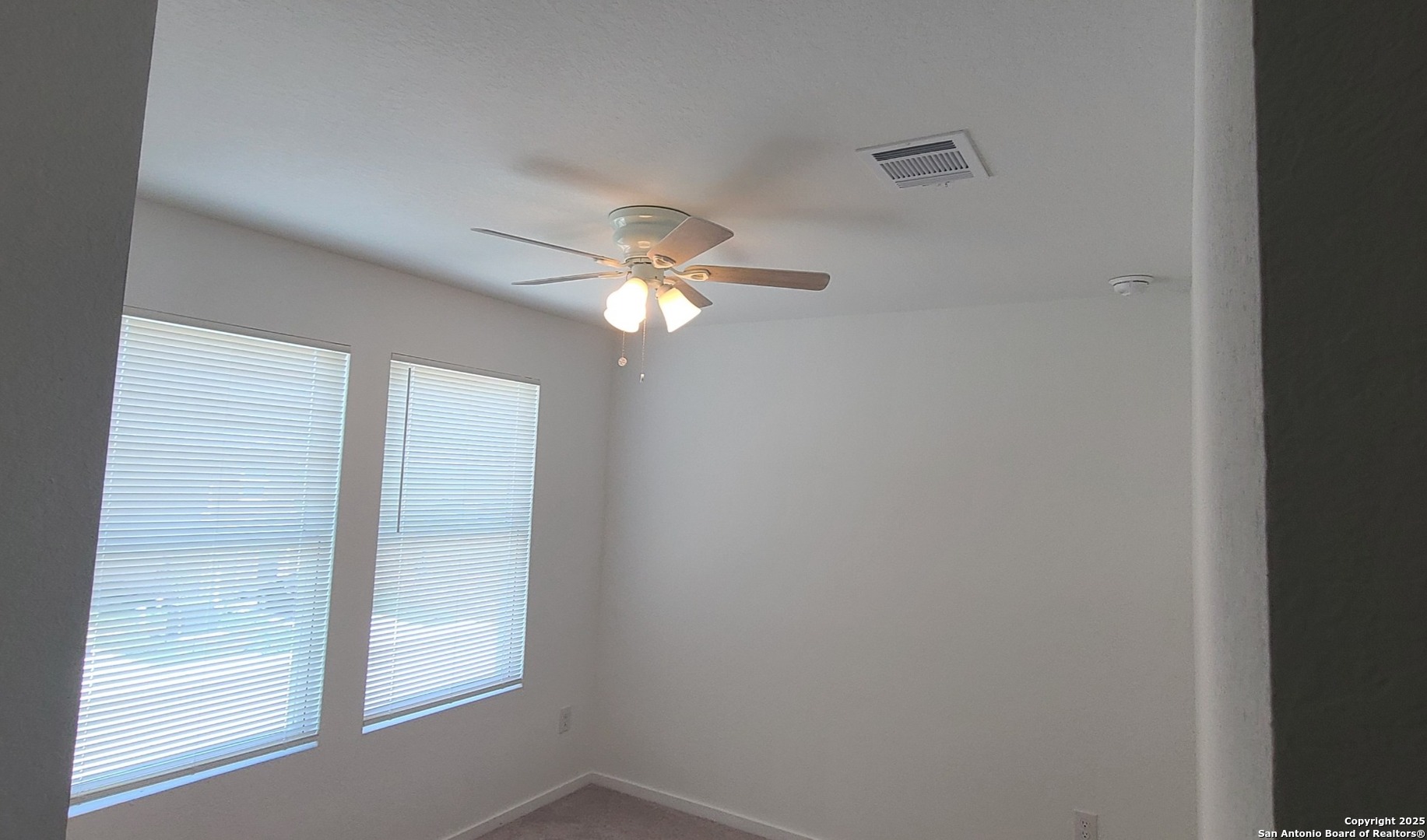 4965 Daisy Blossom Converse, TX 78109 - Photo 20 of 23 an empty room with a chandelier fan and windows