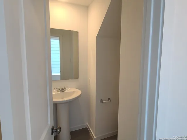 a bathroom with a light fixture a sink and a window