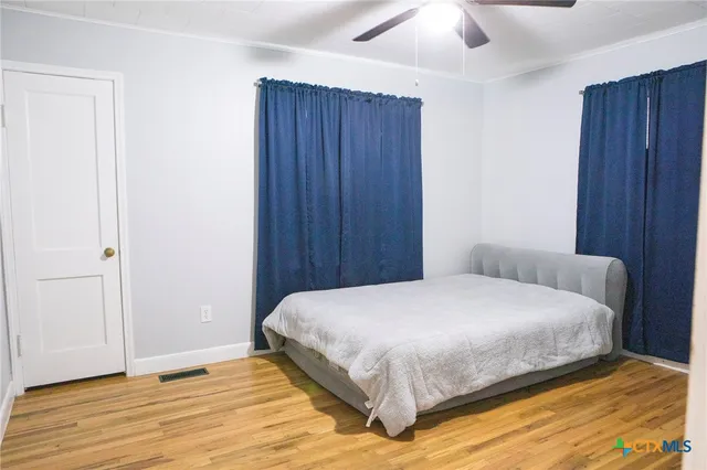 a bedroom with a bed and wooden floor
