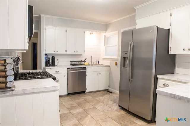 a kitchen with a refrigerator sink stove and cabinets