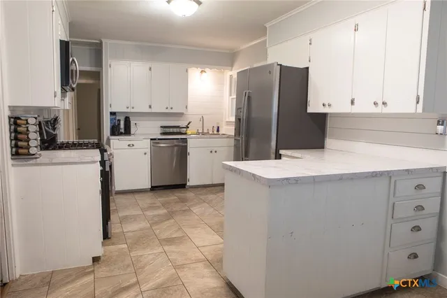 a kitchen with cabinets and stainless steel appliances