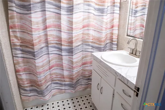 a bathroom with a sink a vanity and a shower curtain