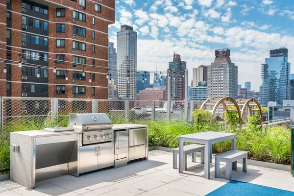 a view of roof deck with a barbeque and wooden stairs