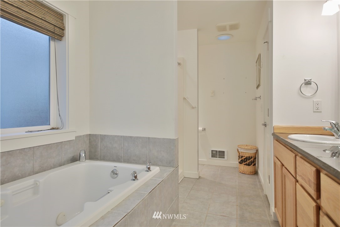 1813 Watkins Road Freeland, WA 98249 - Photo 20 of 29 a bathroom with a tub a sink and a large mirror