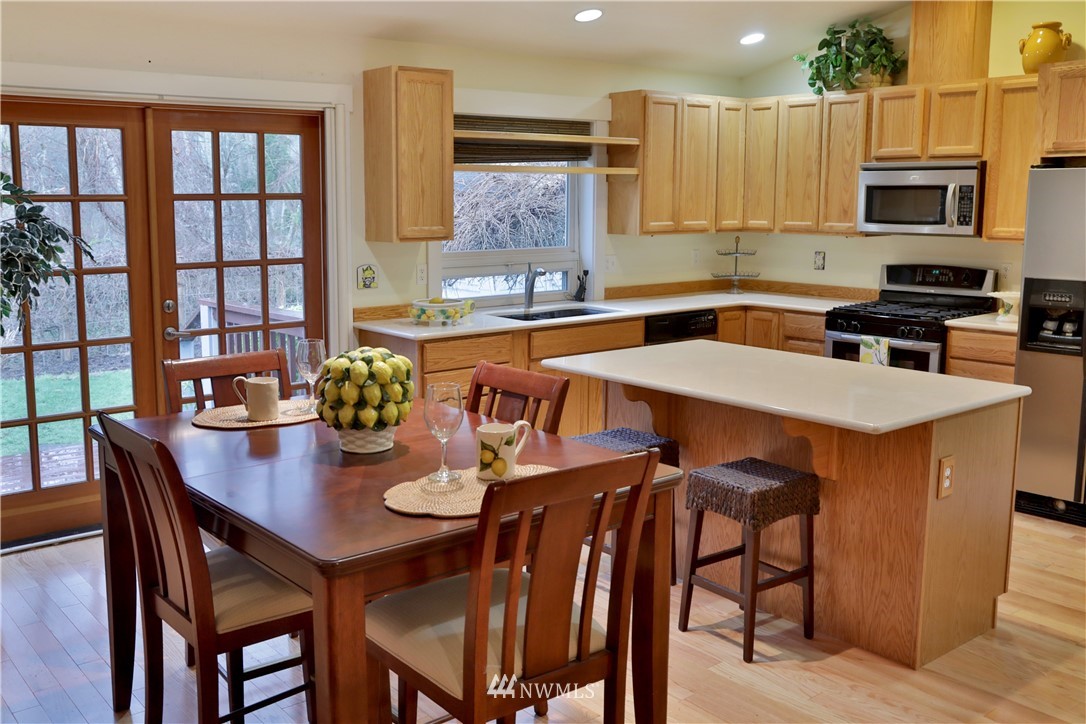 1813 Watkins Road Freeland, WA 98249 - Photo 6 of 29 a kitchen with stainless steel appliances granite countertop a table chairs and a refrigerator