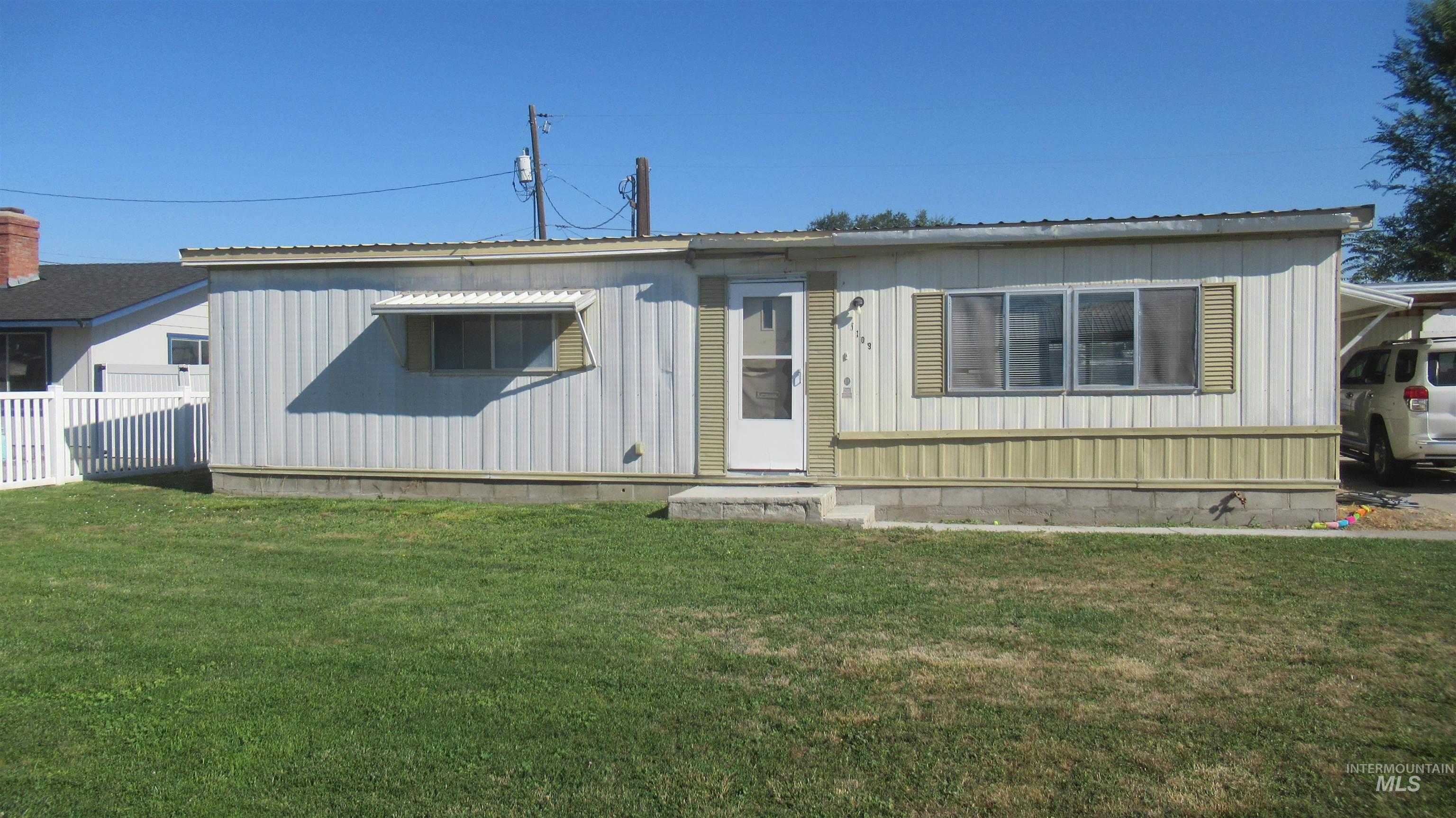 1109 West D Vale, OR 97918 - Photo 1 of 19 Front exterior with light-colored vertical siding, contrasting horizontal paneling, and multiple windows