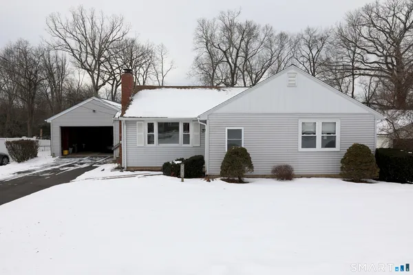 a front view of a house with a yard covered in snow