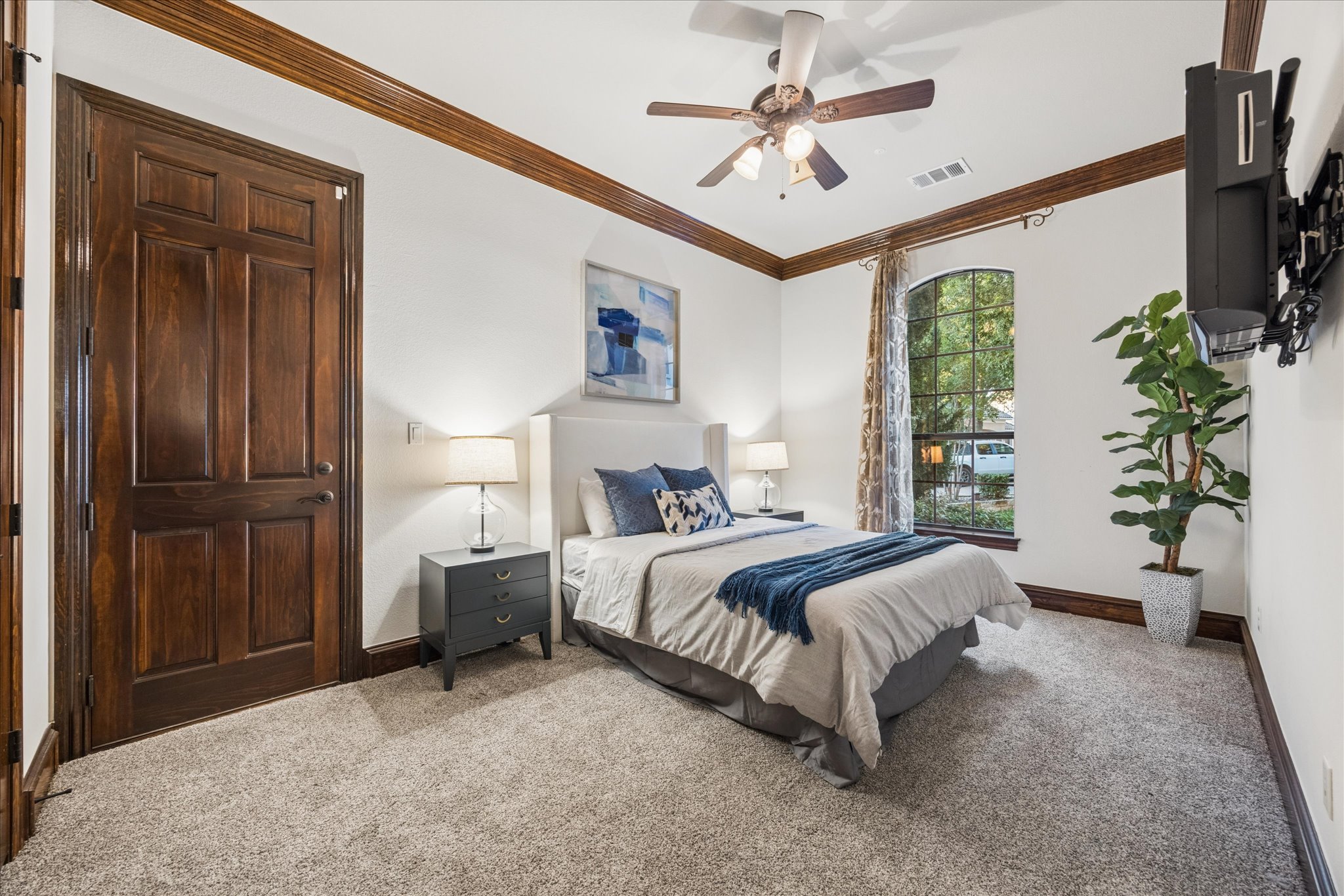 11805 Ranchview Court Austin, TX 78732 - Photo 15 of 36 Carpeted room featuring a ceiling fan, a prominent arched window, dark wood-finish trim and door, and white walls