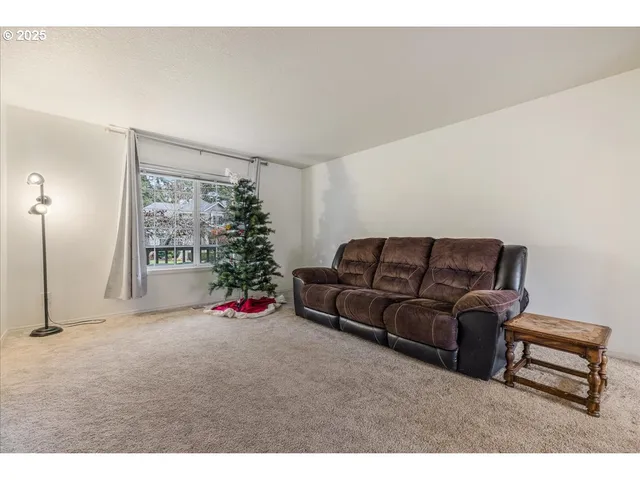 a living room with furniture a flower pot and a window