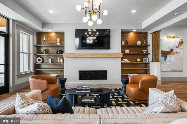 a living room with furniture a flat screen tv and kitchen view