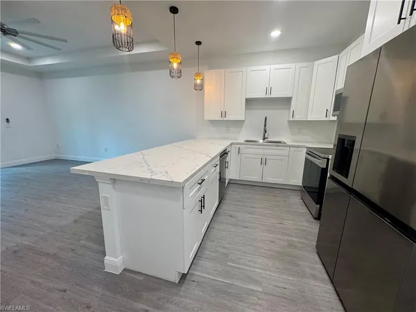 a kitchen with white cabinets stove and refrigerator