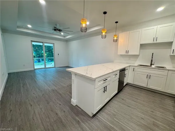 a kitchen with a white cabinets and wooden floor