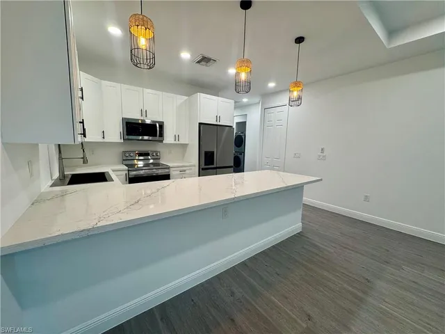 a kitchen with kitchen island a counter space a sink and appliances
