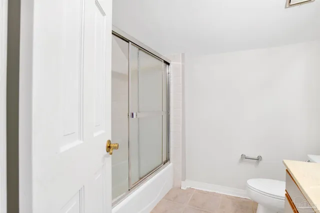 a bathroom with a granite countertop shower and a toilet