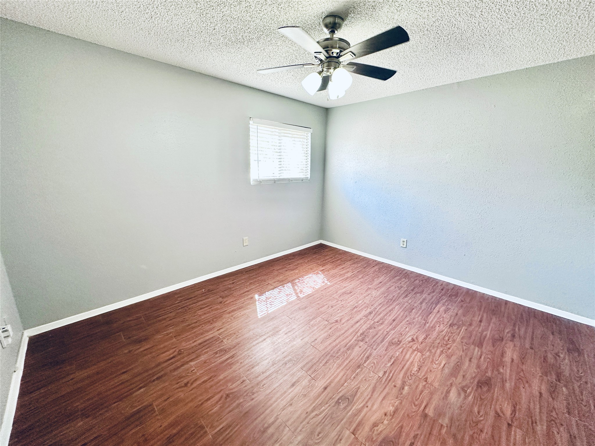 3702 South 2nd Street, Unit 107 Austin, TX 78704 - Photo 4 of 12 a view of an empty room with wooden floor and a ceiling fan