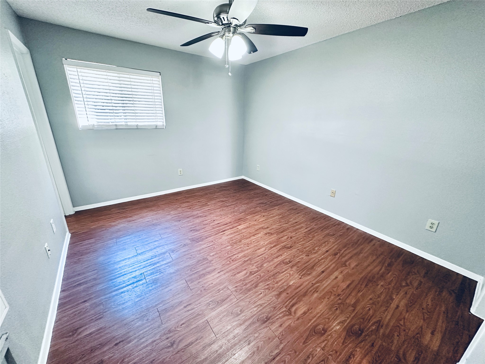 3702 South 2nd Street, Unit 107 Austin, TX 78704 - Photo 8 of 12 an empty room with wooden floor fan and windows