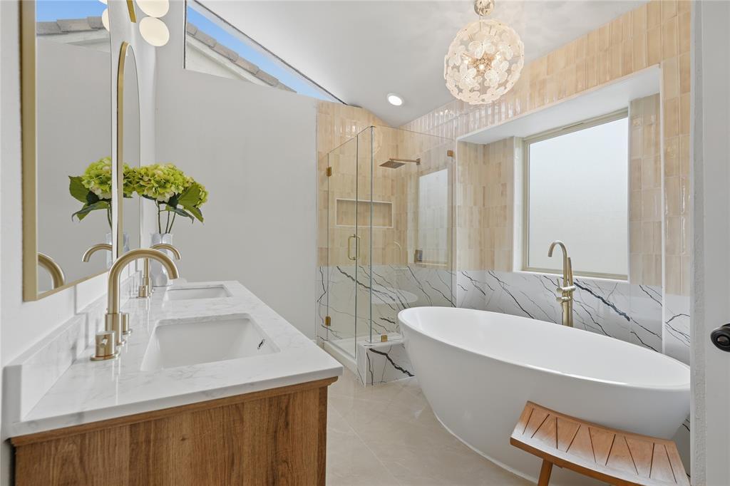 17118 Planters Row Addison, TX 75001 - Photo 16 of 18 Modern bathroom featuring a freestanding soaking tub, a frameless glass shower enclosure with a built-in niche, and a double vanity with a wood-finish base and light-toned countertop
