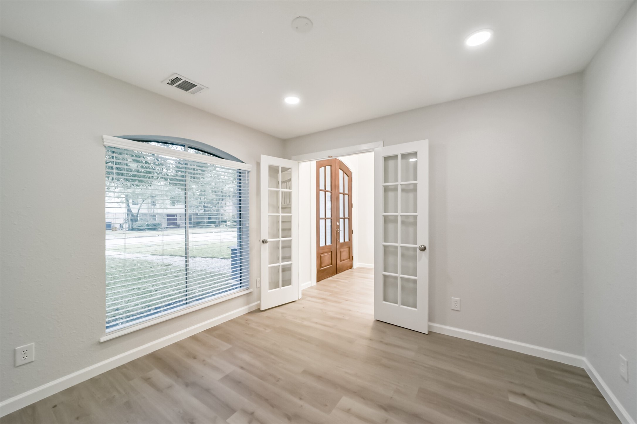 15610 Ripplewind Lane Houston, TX 77068 - Photo 18 of 44 an empty room with wooden floor and windows