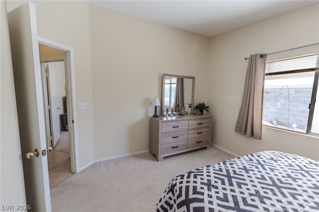 4994 Mascaro Drive Las Vegas, NV 89122 - Photo 11 of 30 Well-lit sleeping quarters with plush carpeting and a wide window.