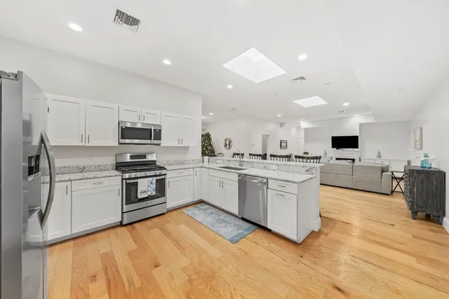 a kitchen with white cabinets and stainless steel appliances