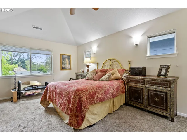 a spacious bedroom with a bed a table and a large mirror