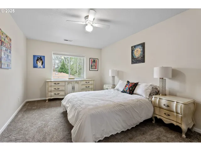 a spacious bedroom with a bed a table and a chandelier