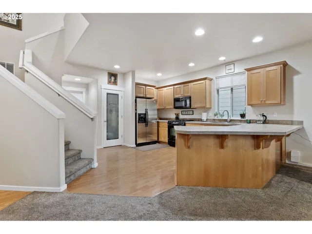 a living room with stainless steel appliances kitchen island granite countertop furniture and a view of kitchen