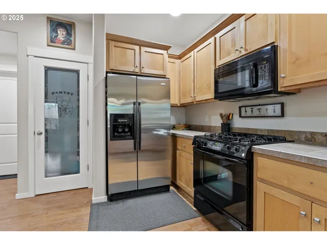 a kitchen with stainless steel appliances granite countertop a stove a microwave and a refrigerator