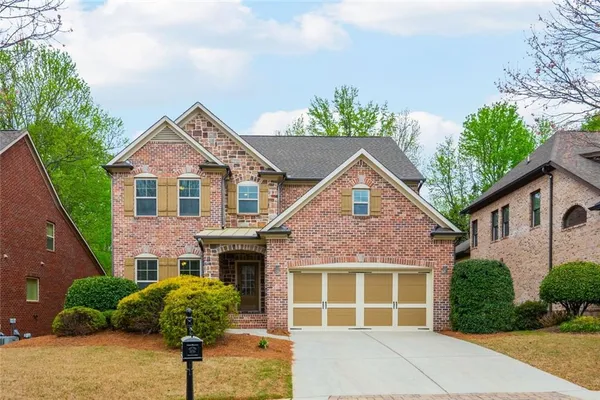 a front view of a house with a yard and potted plants