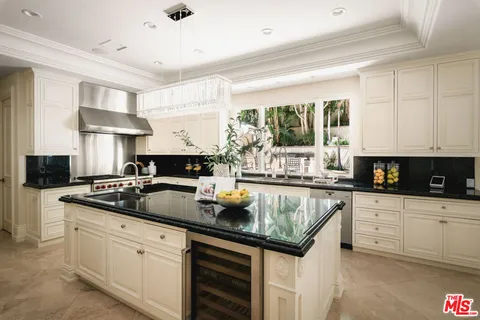 a kitchen with stainless steel appliances granite countertop a sink a stove and cabinets