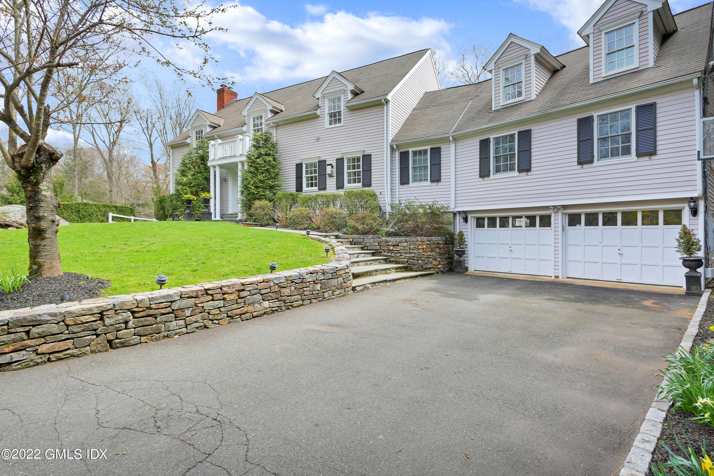 22 Indian Mill Road Cos Cob, CT 06807 - Photo 3 of 24 a front view of a house with a yard and garage
