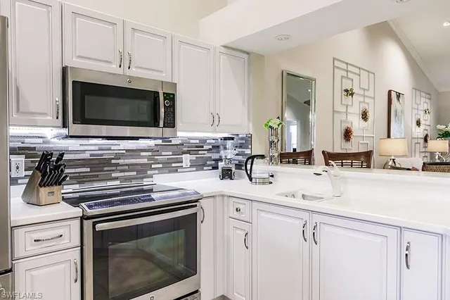 a kitchen with stainless steel appliances granite countertop a sink stove and microwave
