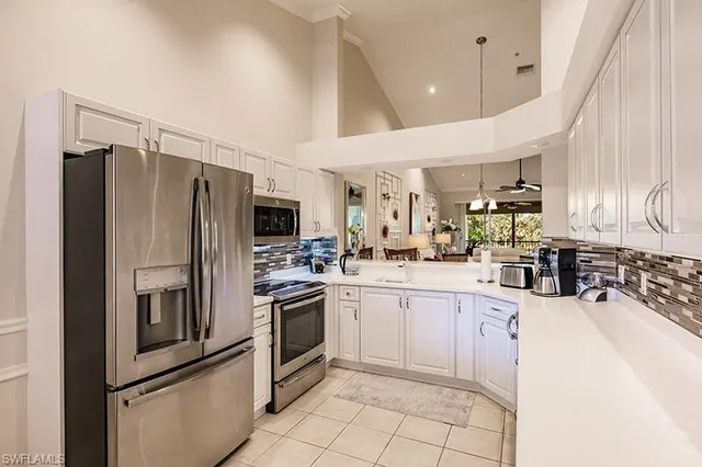 a kitchen with stainless steel appliances a refrigerator sink and microwave