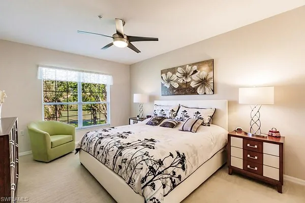 a bedroom with a bed and a large window