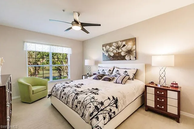 a bedroom with a bed and a large window