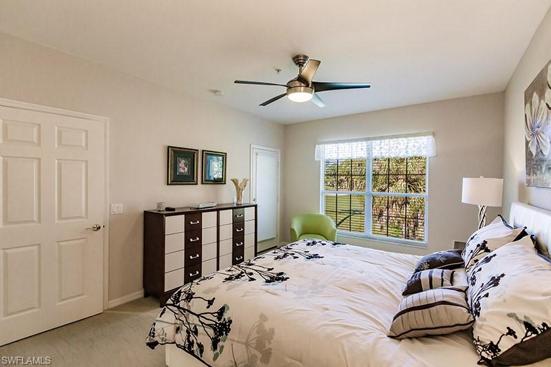 8135 Celeste Drive, Unit 4218 Naples, FL 34113 - Photo 22 of 37 a bedroom with a bed and a large window